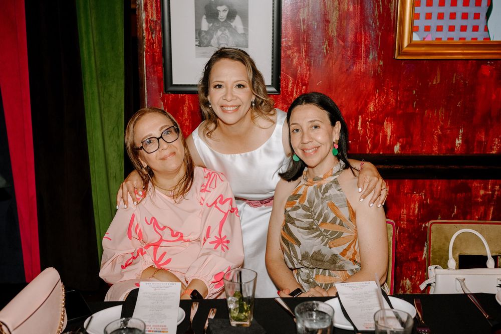 A group dines together at a restaurant with red walls in close proximity.