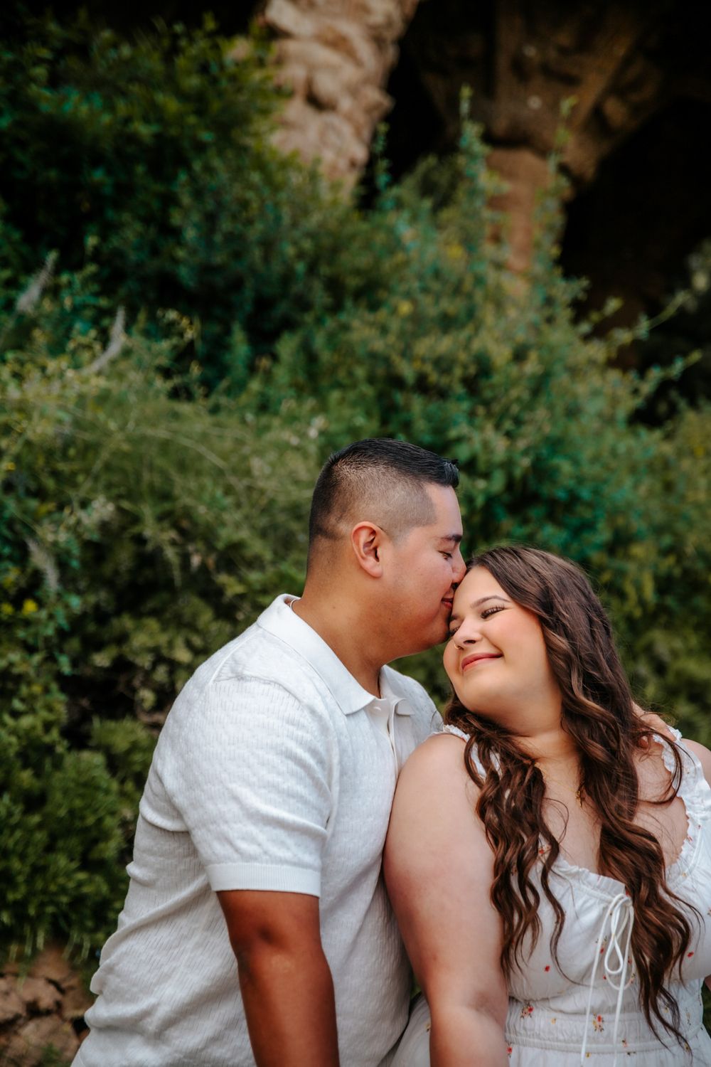 Couple laughing while strolling through Park Güell’s charming gardens.