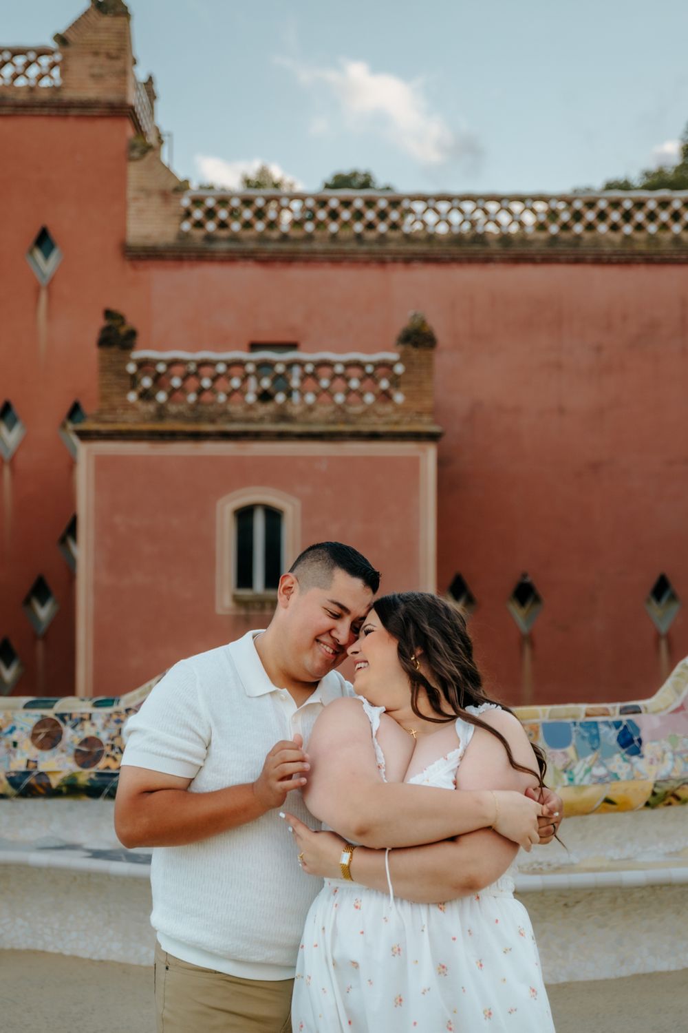 Romantic portrait of the couple framed by Park Güell’s iconic tiles.
