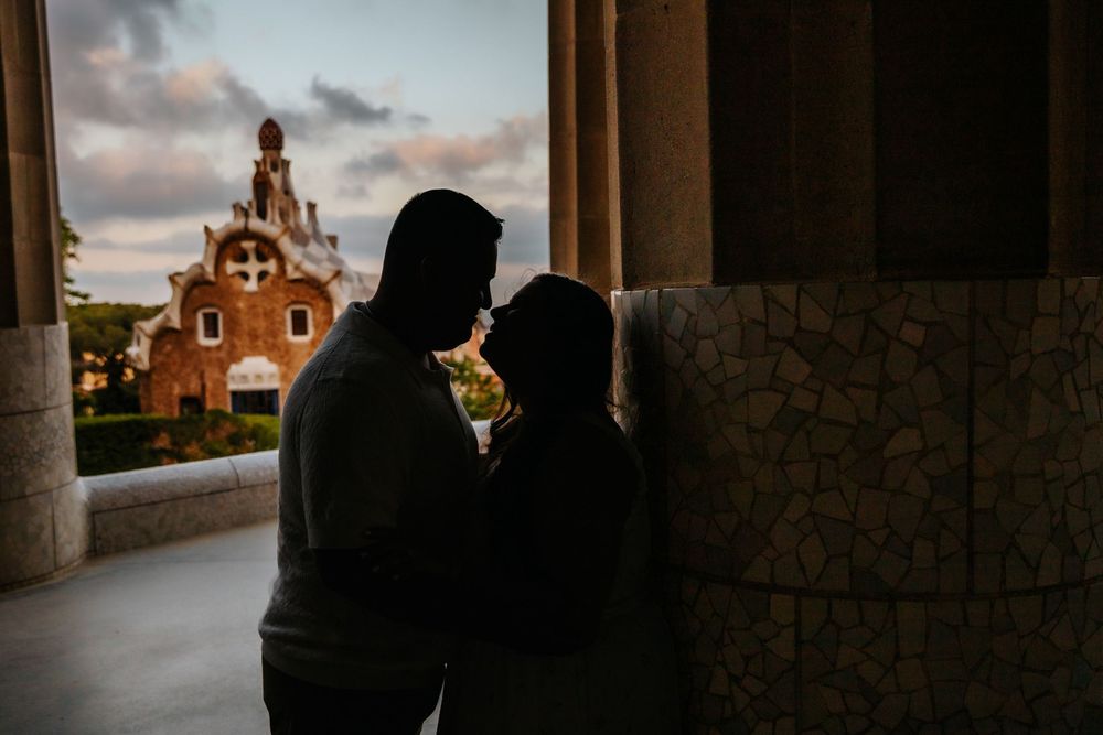 Natalia leaning into Hector during their playful anniversary session in Park Güell.