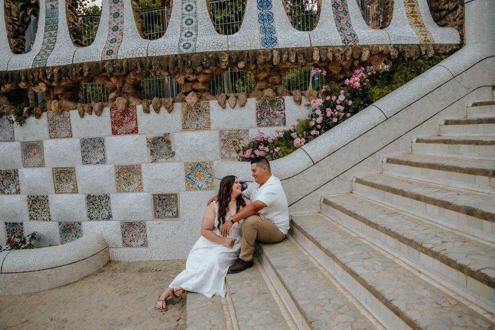 Couple walking together on a colorful pathway in Park Güell for their anniversary.