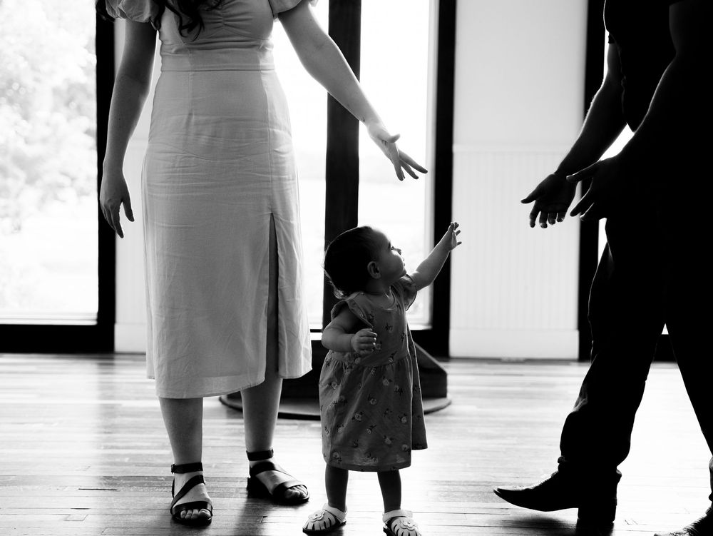 Silhouettes of people's legs and feet against a white background making a dramatic line composition across the frame.