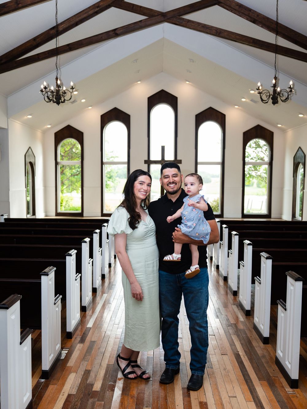 Interior series of a white chapel with wood floors and gothic windows showing family portraits in various poses along aisle.