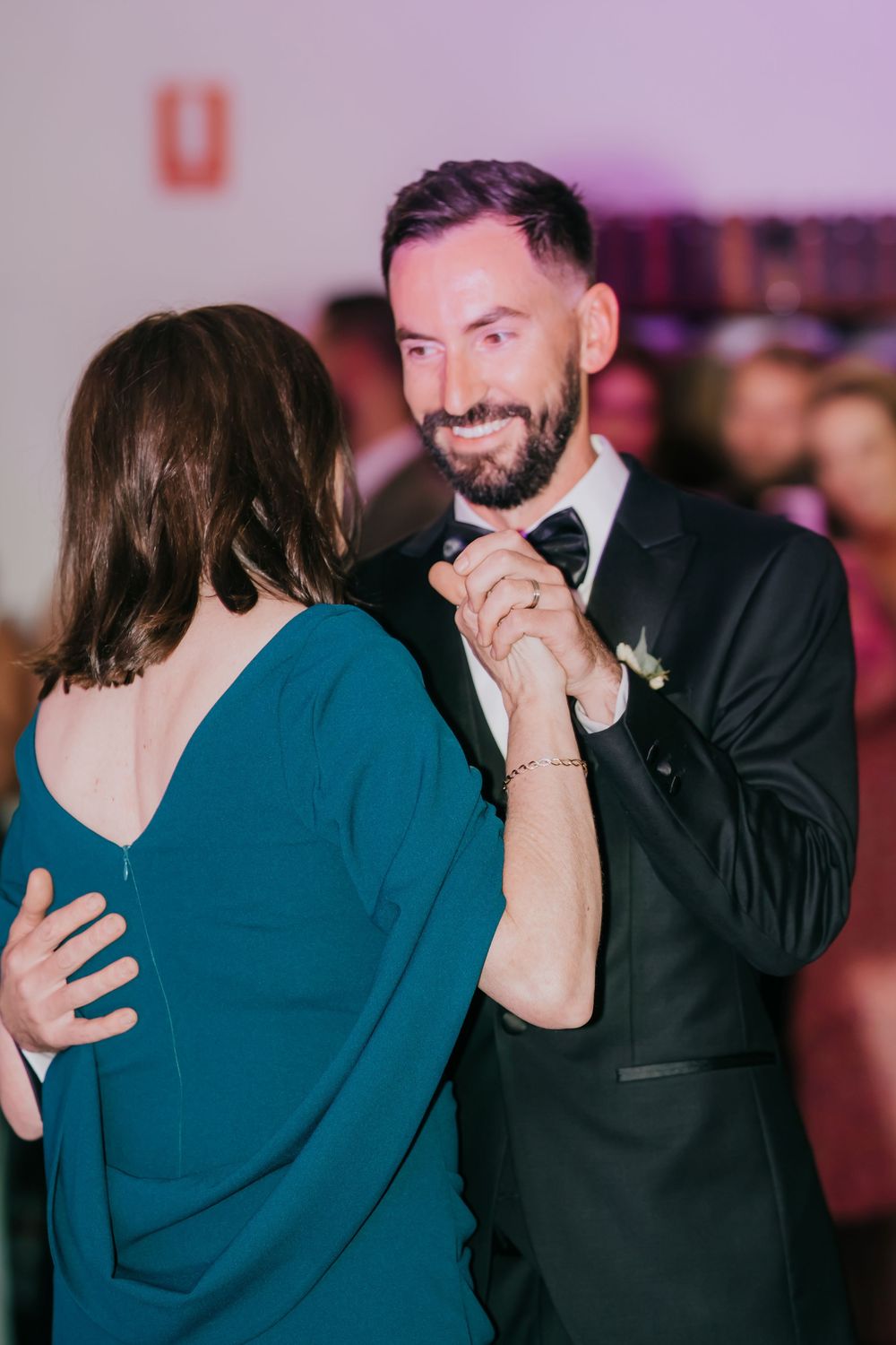 A couple shares intimate laughing moments in a sequence of candid photographs at an indoor event with purple lighting.