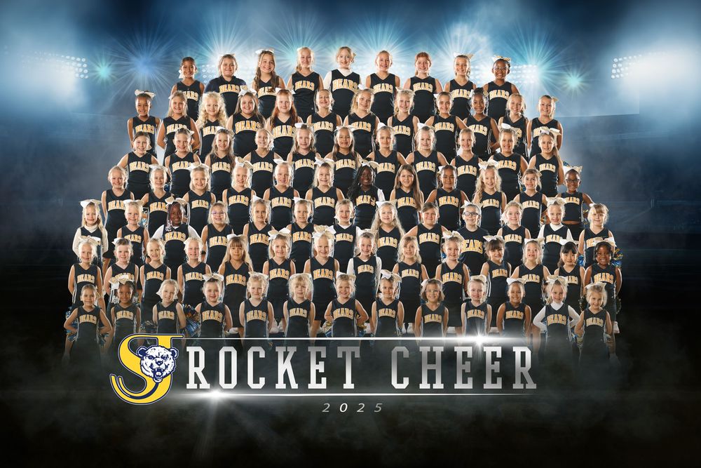 Large group photo of cheerleading team members arranged in rows with team banner.