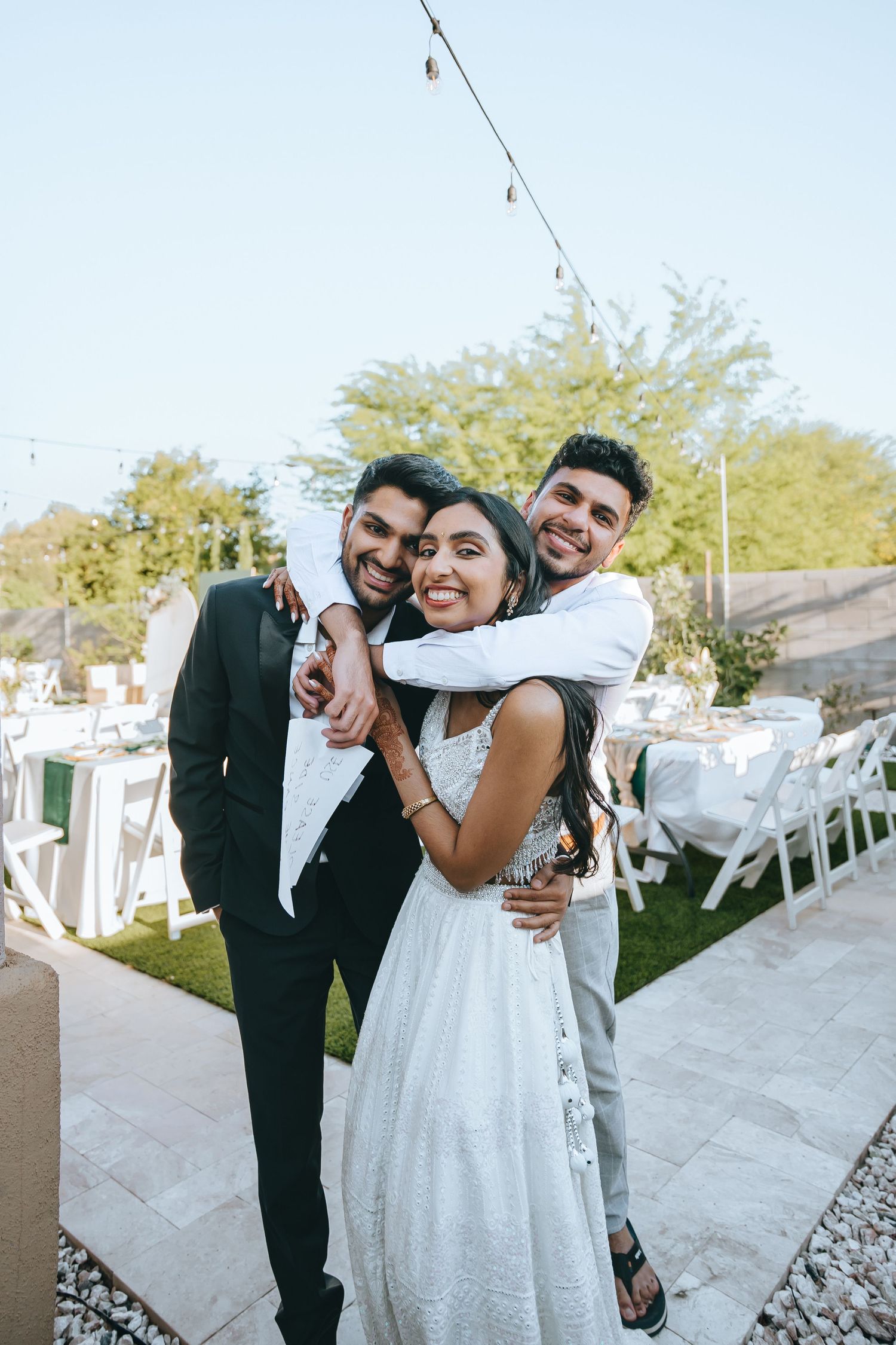 Joyful candid moments between wedding couple at outdoor reception.