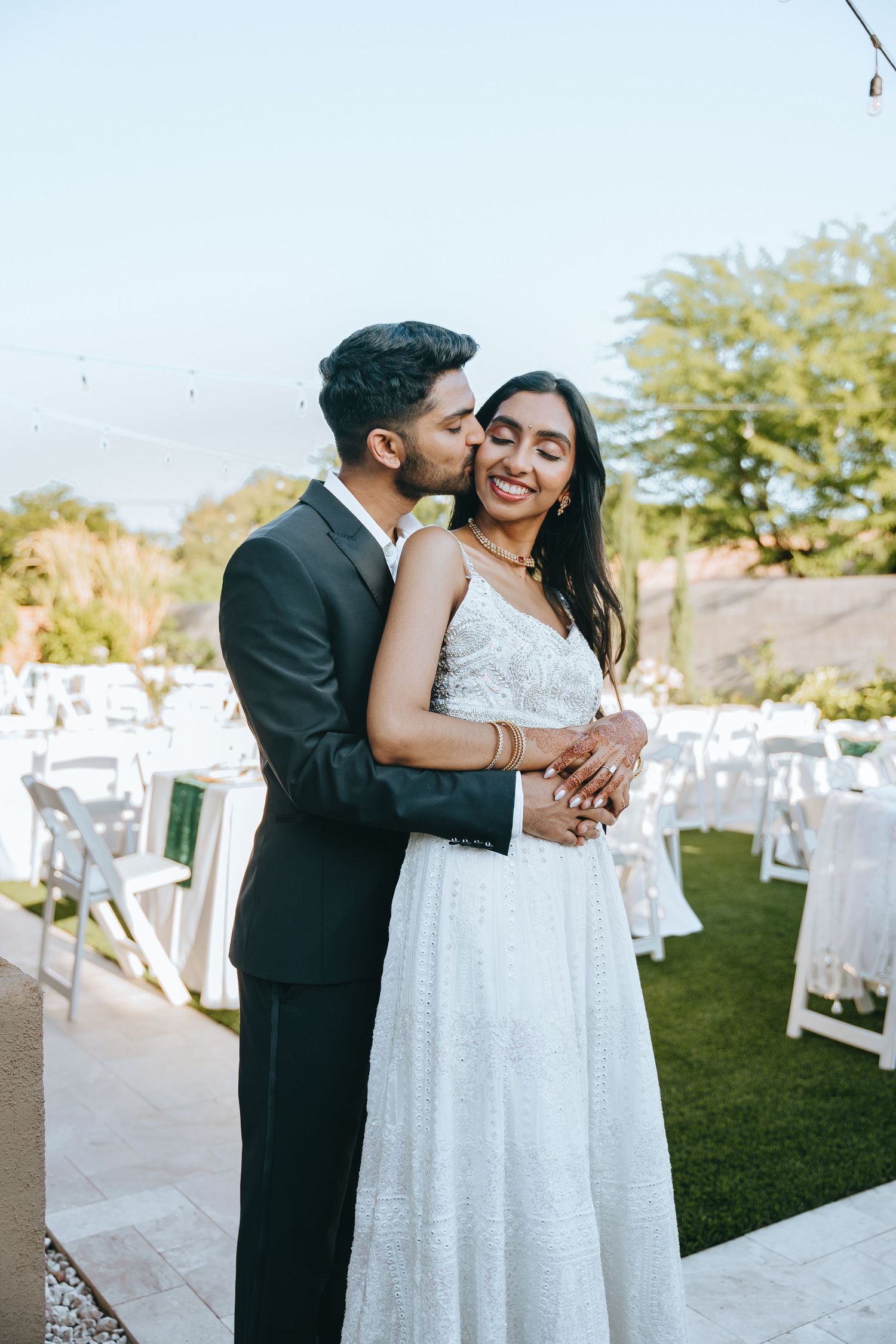 A tender moment between newlyweds at an outdoor wedding reception.