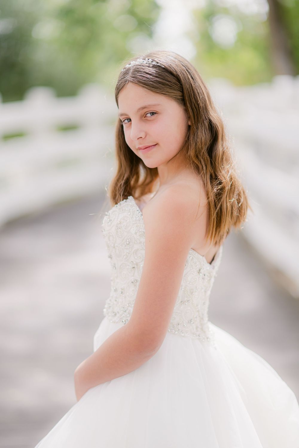 Several close-up shots of a young person wearing a white lace wedding dress with delicate details, photographed outdoors.