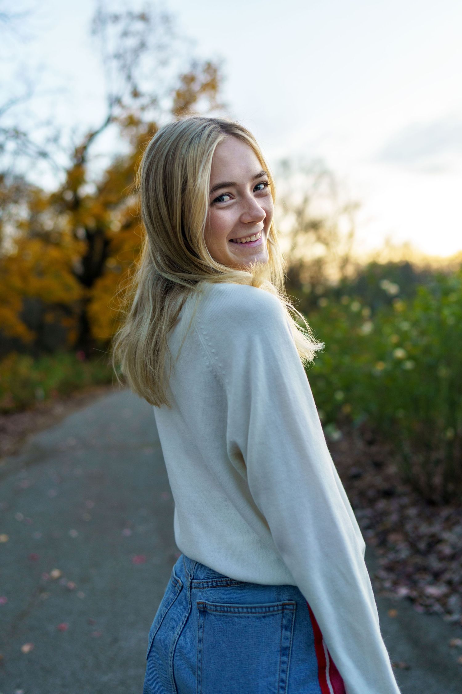 High school senior walking along a tree-lined path in Clintonville during golden hour, by Jamie Macey Photography, in Columbus, Ohio.
