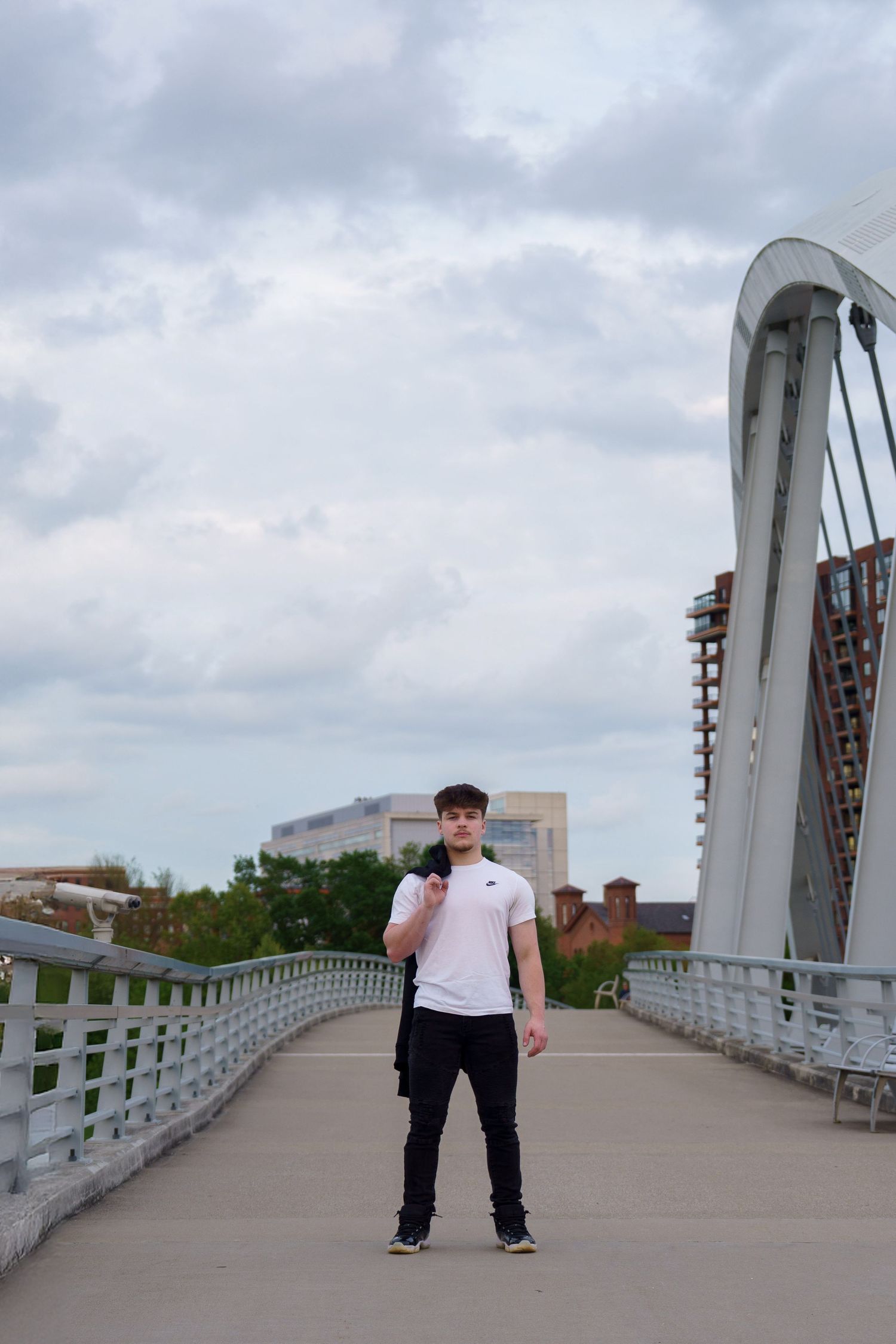 High school senior standing on a pedestrian bridge in downtown Columbus, by Jamie Macey Photography, in Columbus, Ohio.