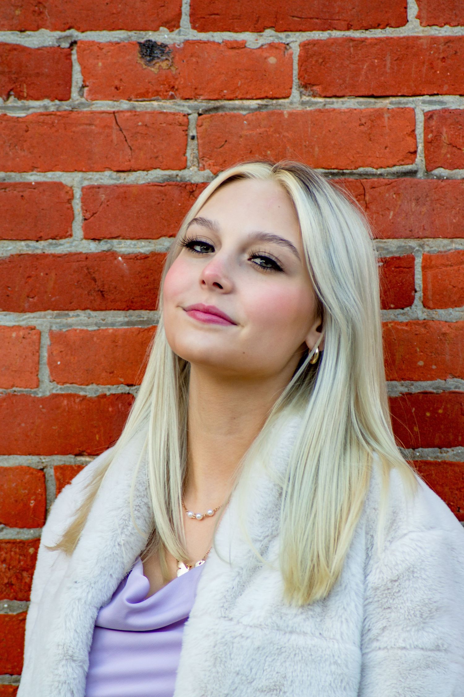 High school senior portrait in front of a red brick wall, by Jamie Macey Photography, in Columbus, Ohio.