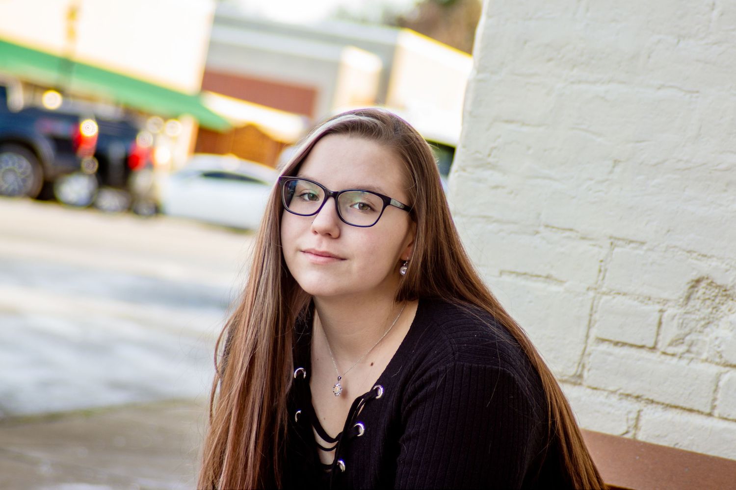 Senior in urban historic downtown sitting on bench in Canal Winchester, Ohio by Jamie Macey Photography