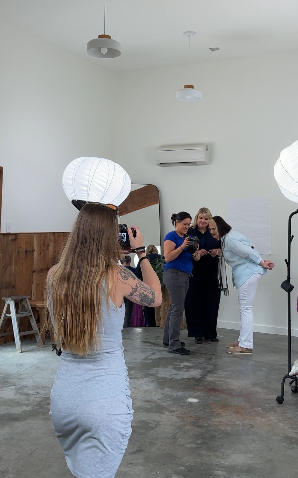 women behind the scenes of personal branding photoshoot 2 women being shown photo while other takes photo in Auburn, WA studio