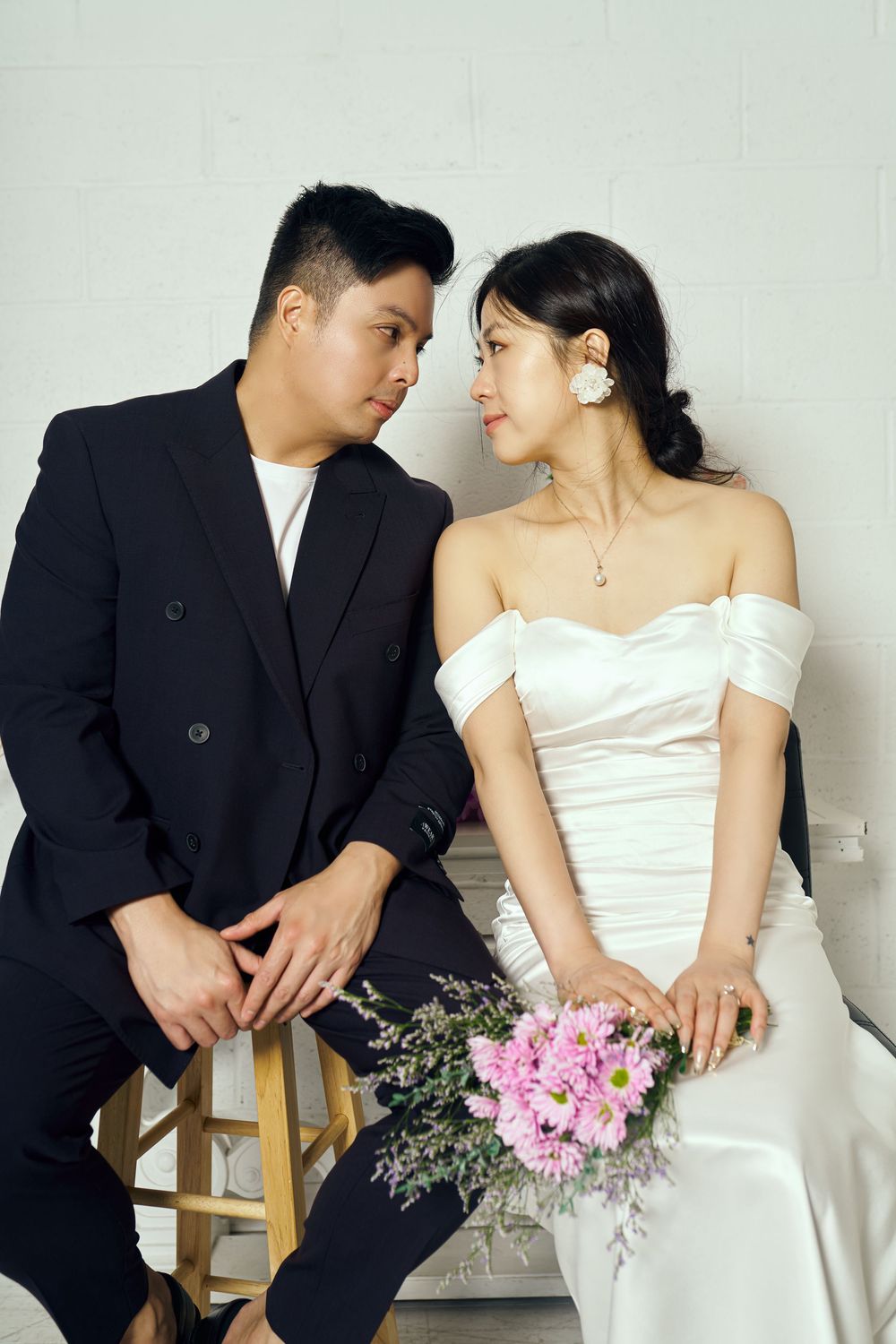 A couple in wedding attire poses intimately across multiple romantic portrait shots with pink bouquet details. studio photo session