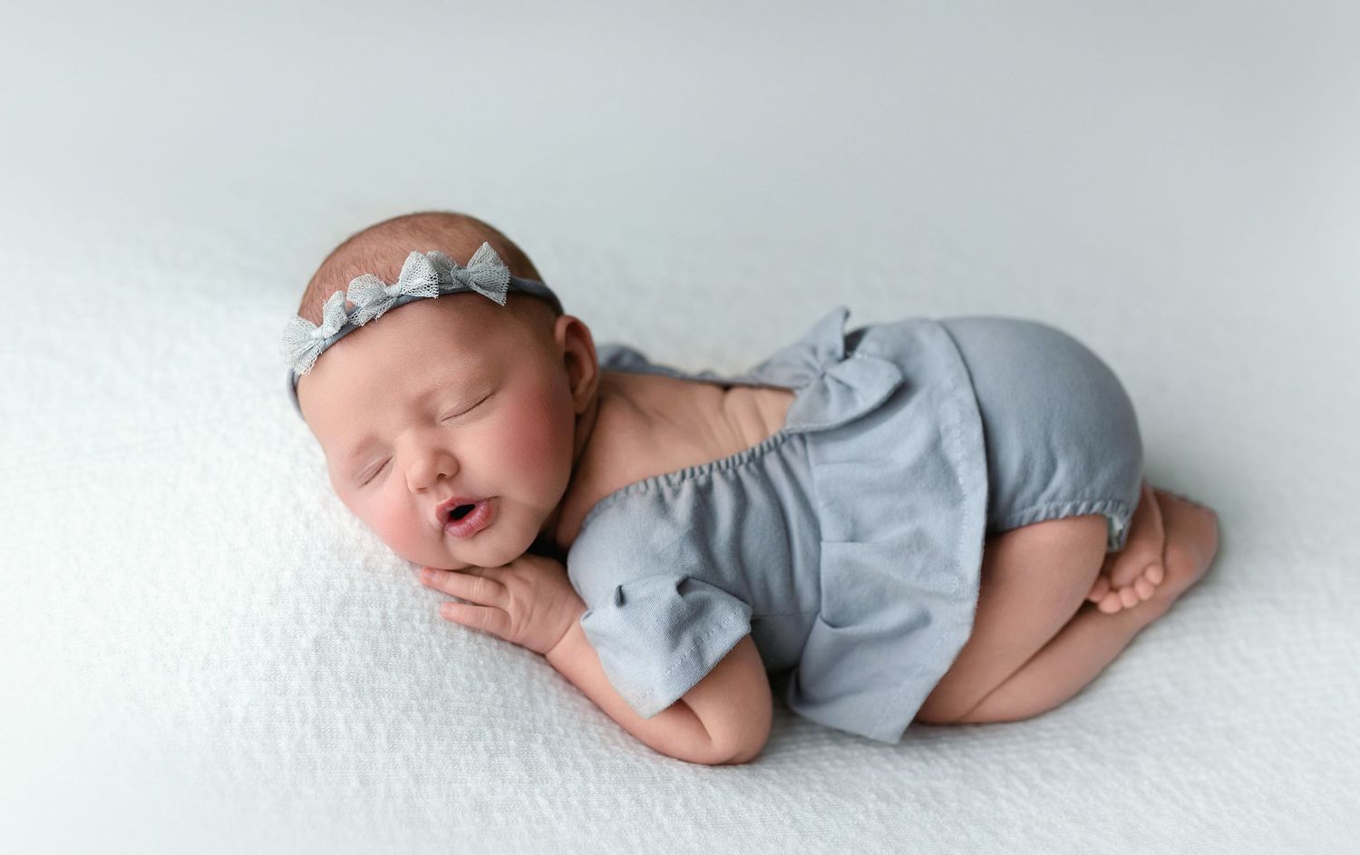 A sweet newborn girl with a gray outfit on in the bum-up pose.  - Greenville SC newborn photographer - Easley SC newborn photographer