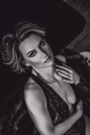 Black and white sensual boudoir photo shoot with dramatic shadows and lace details.