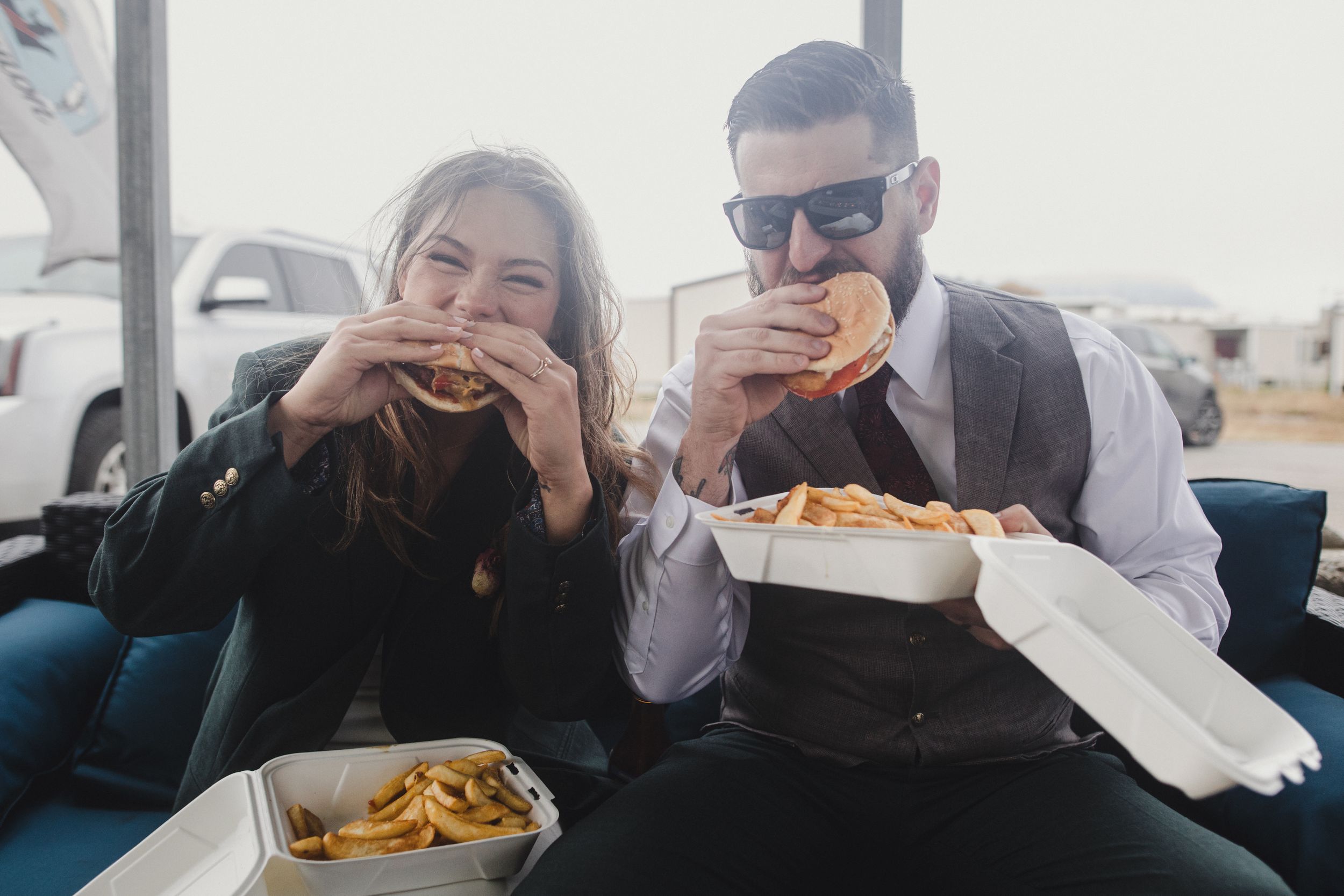 Couple enjoying fast food together while dressed in formal attire.