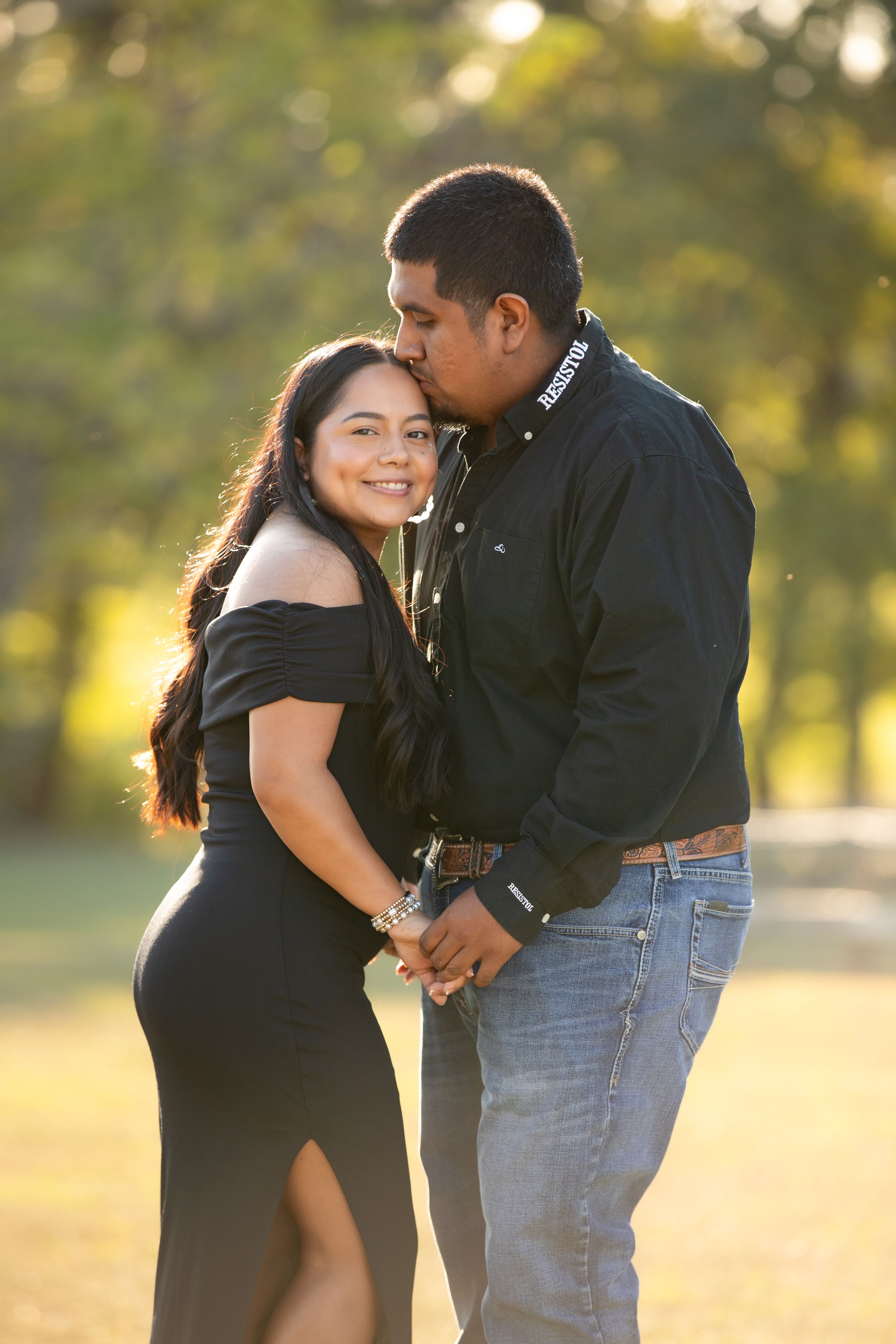 A couple shares romantic moments in a park during golden hour, captured in a series of candid photographs.