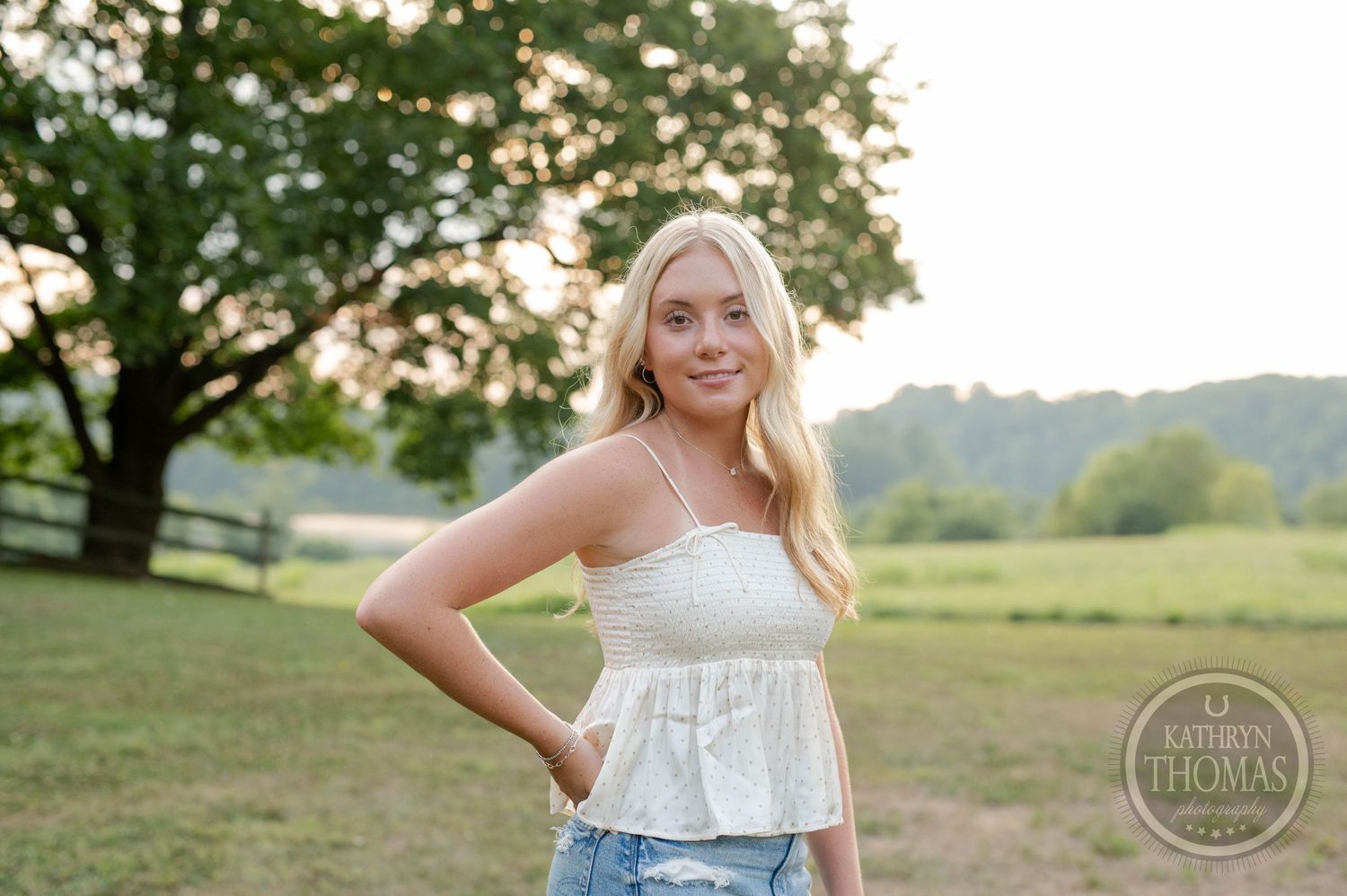 Rustic outdoor portrait in a grassy field with trees at golden hour.