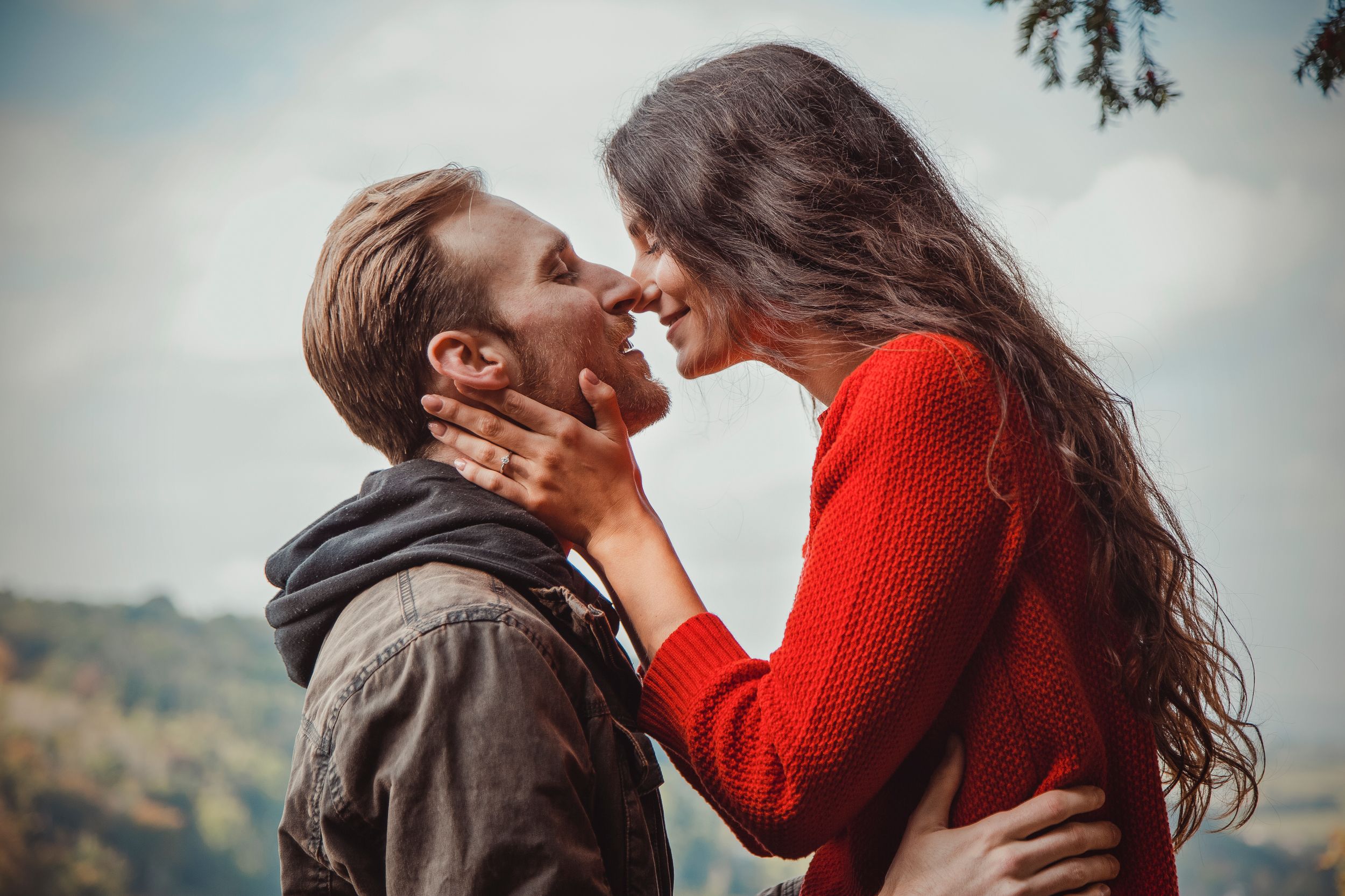 An intimate couple's portrait session in nature with warm lighting and mountain views.