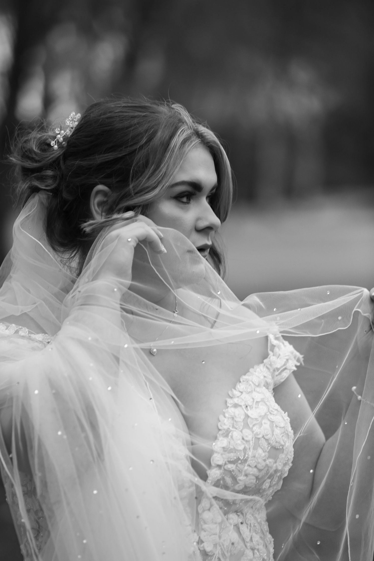 An ethereal bridal portrait featuring delicate veil details in black and white.
