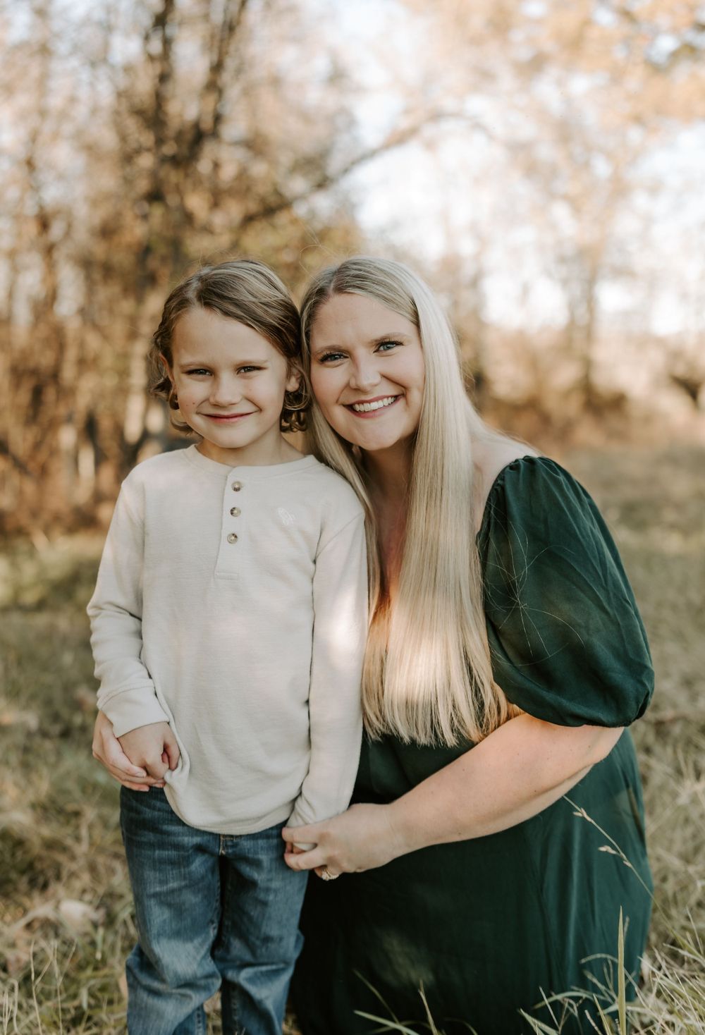 Mother and child smiling together during outdoor fall photo session.