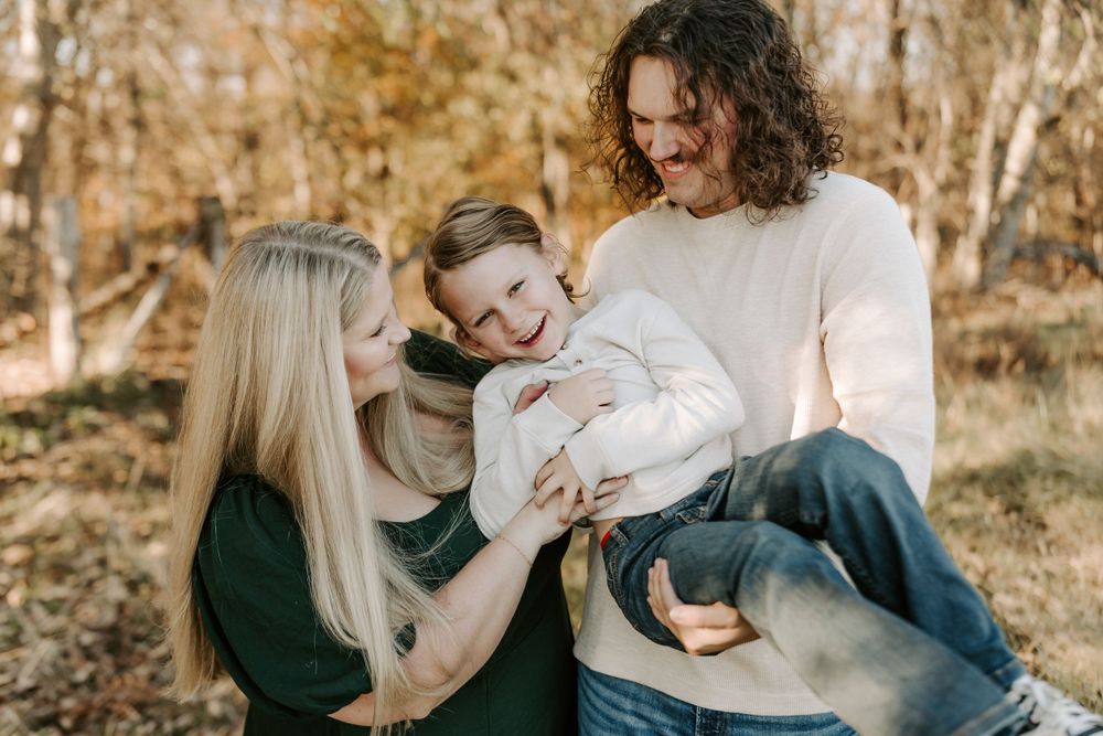 Playful family moments captured during fall photoshoot in nature.