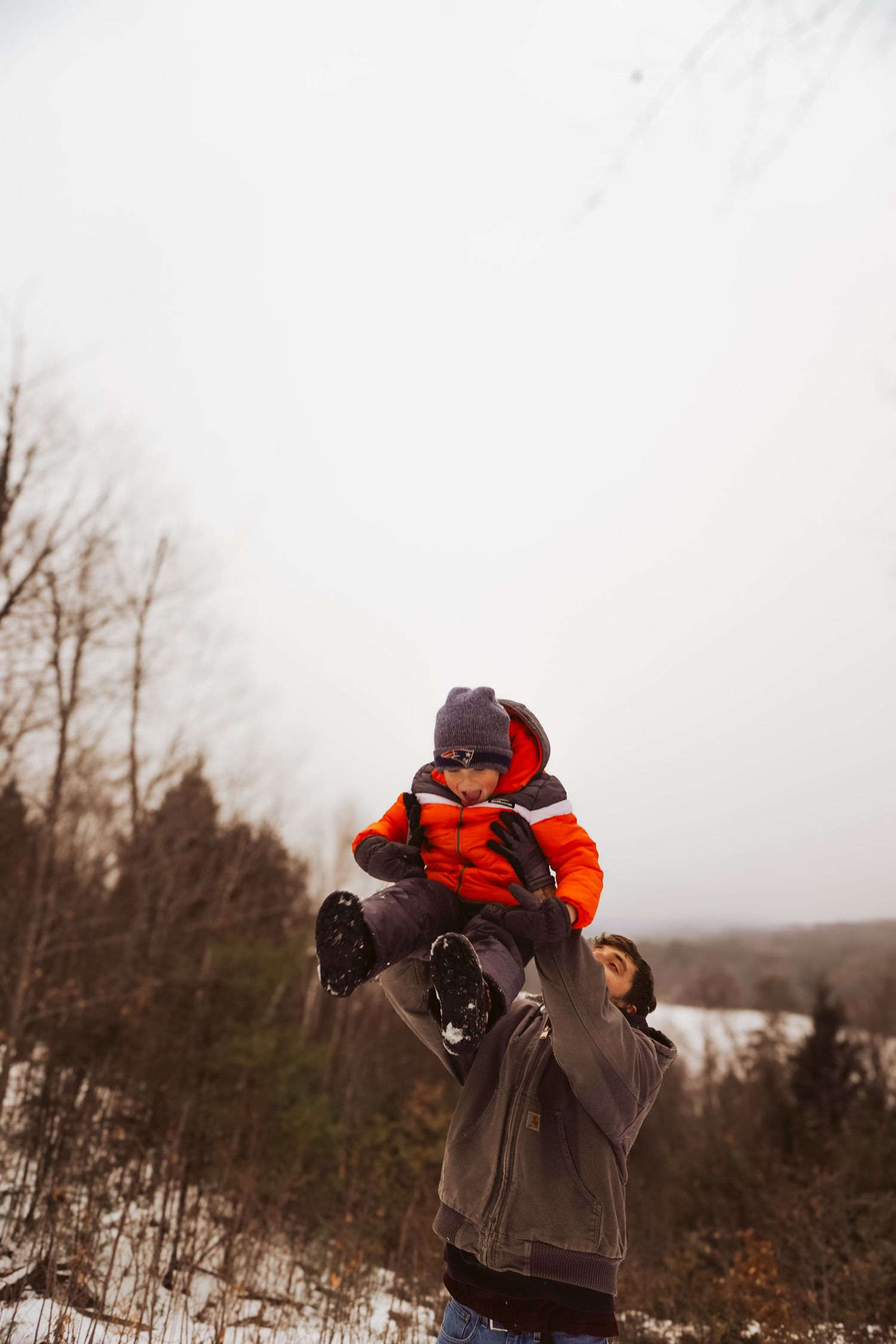 Child being thrown playfully by father in Maine