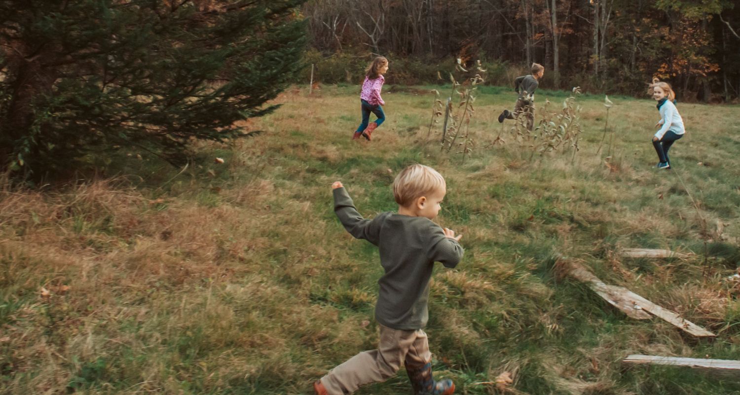 Children playing tag and laughing in Maine