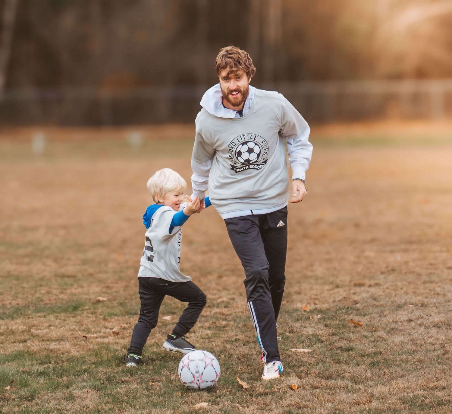 Father and Son playing soccer in the sun in Maine