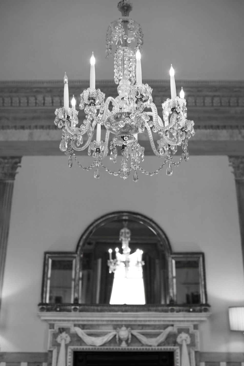 Interior room with ornate crystal chandeliers and classical architectural details.