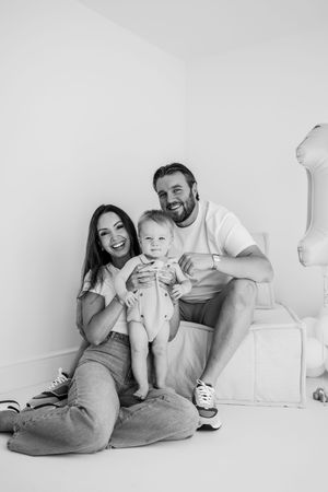 A series of black and white family portraits showing relaxed, candid moments together on a white backdrop.