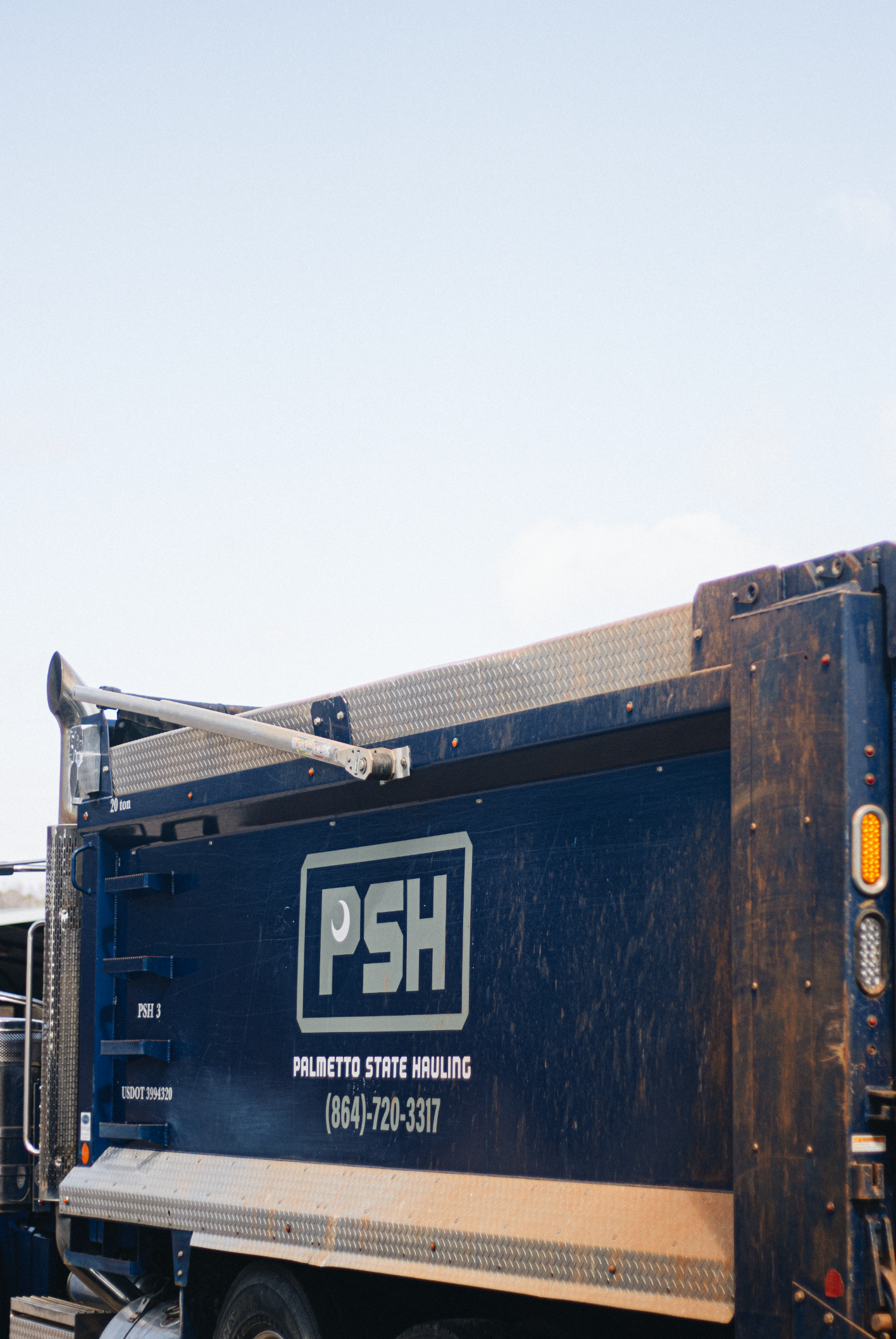 Blue PSH branded truck panel with company contact information displayed.