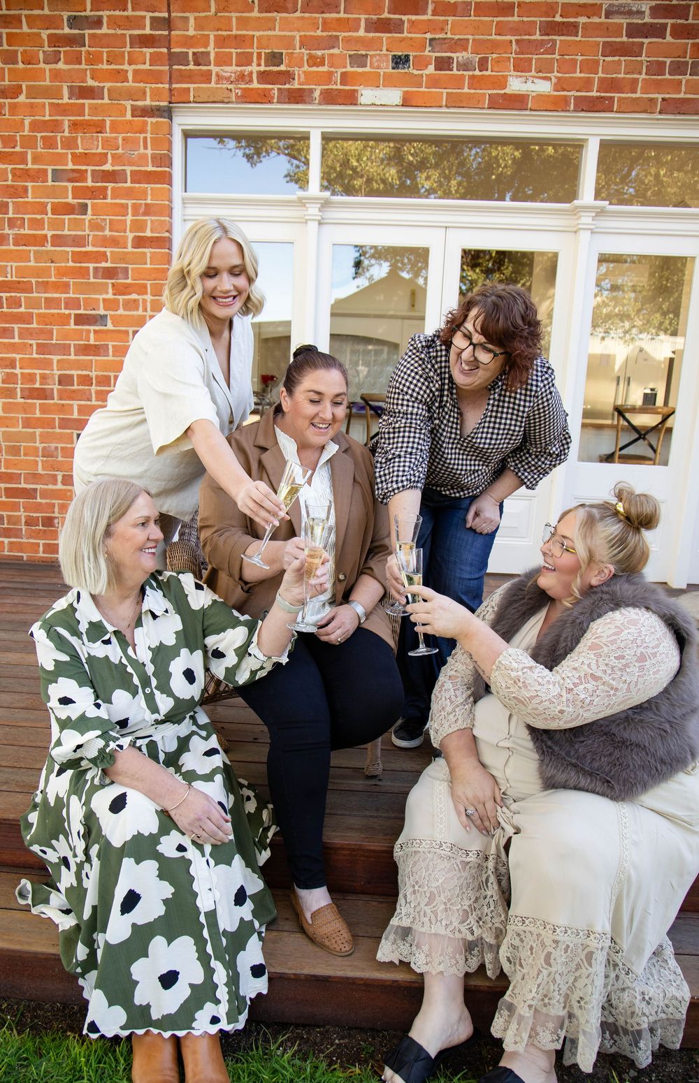 Four candid moments show joyful interactions between people sitting and standing on a wooden porch against a brick wall.