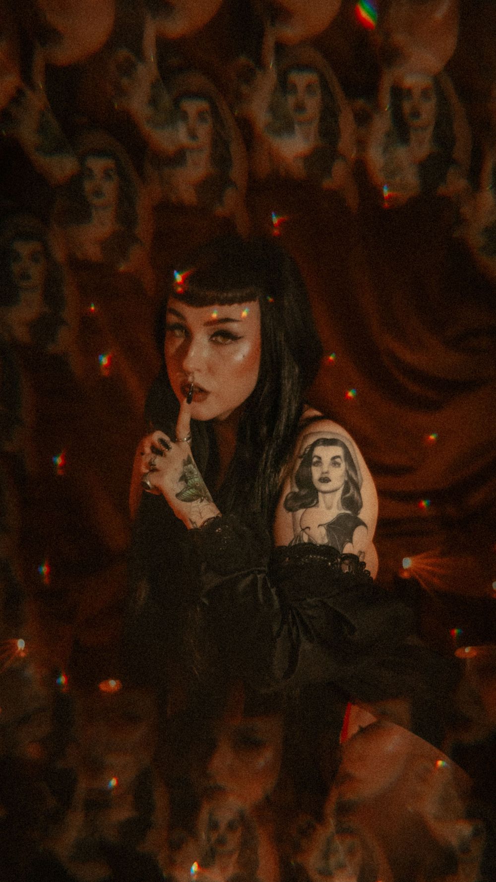 Moody gothic boudoir photography against an orange background with glowing embers and ethereal shadows.