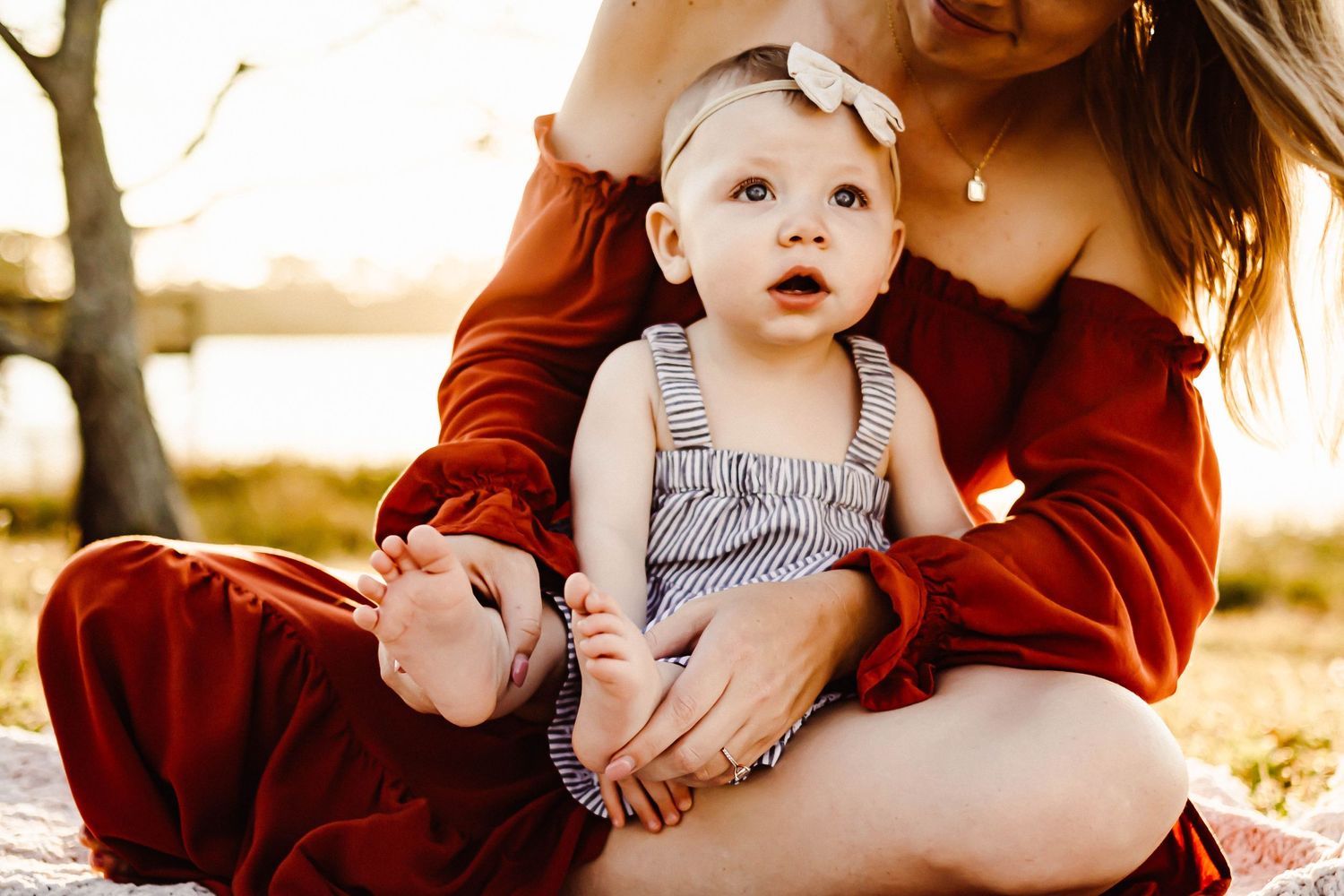 Tender family moment captured during golden hour in a natural outdoor setting.
