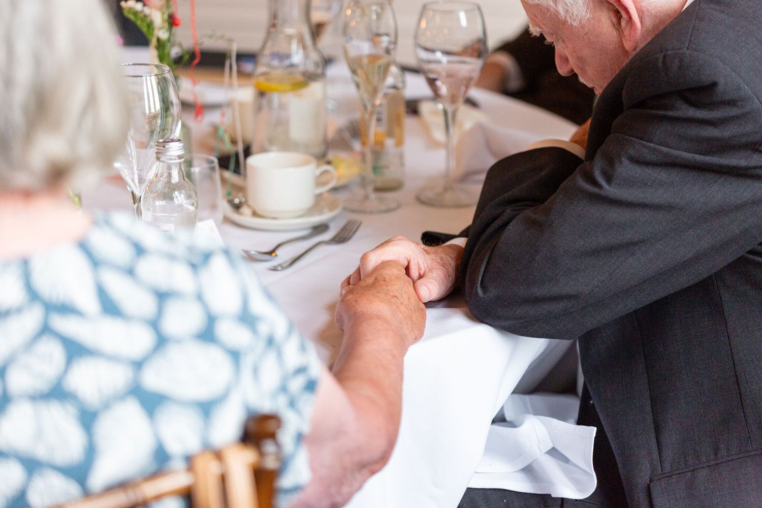 A close-up of hands swirling wine in a crystal glass during a professional tasting event.