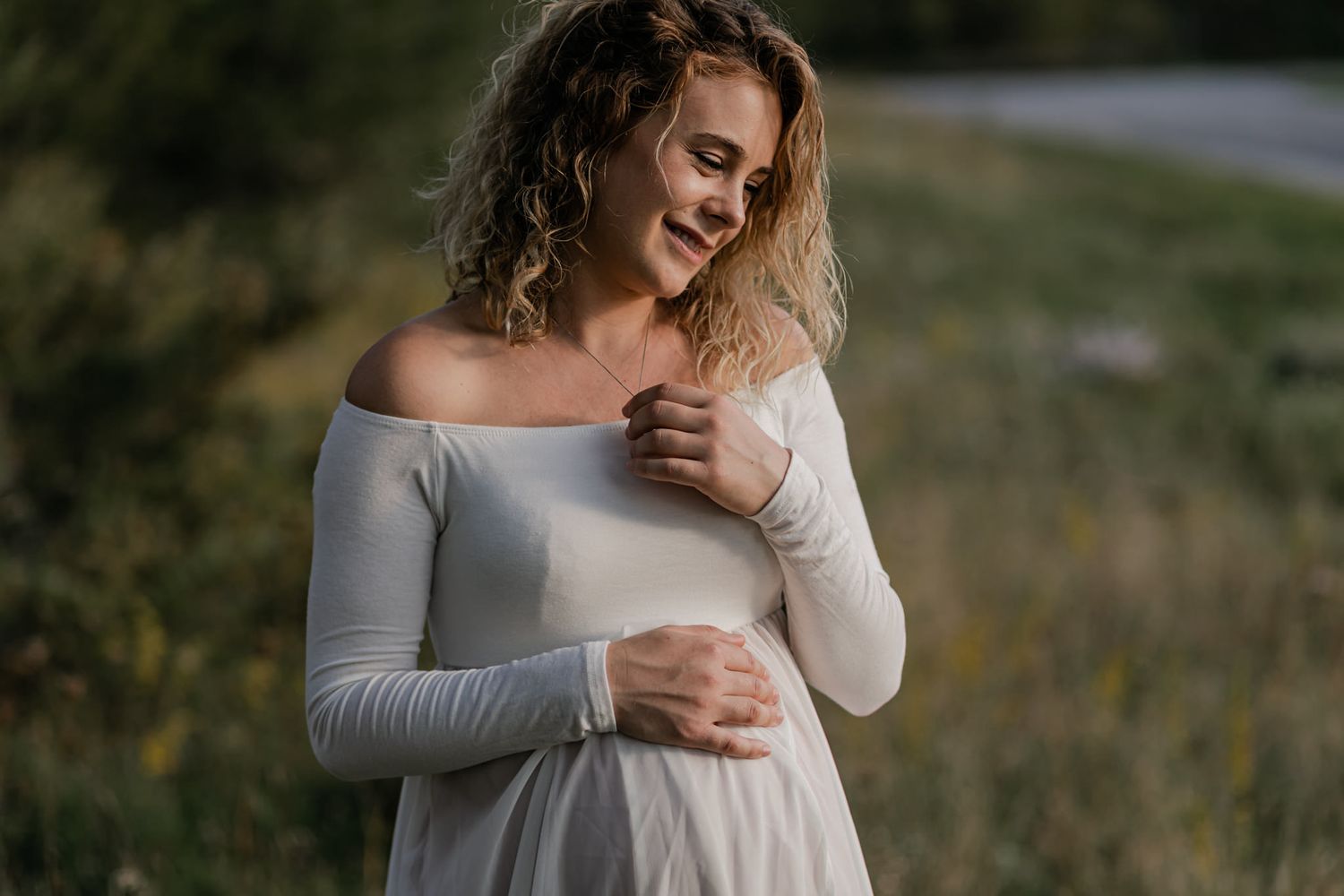 Maternity subject detail shot. Close up of her holding her tummy at Cataraqui Creek in Kingston, Ontario.