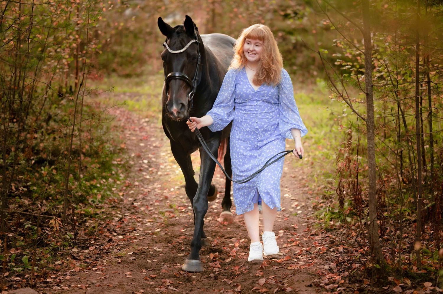 Porträttfoto av en tjej och hennes häst gående på en höstlig stig
Porträttfotograf: Josefina Nordström "Josefina Fotografen"