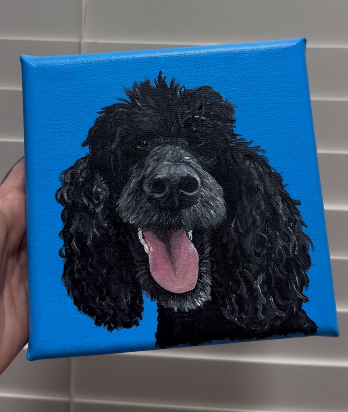 Canvas painting of a happy black standard poodle with tongue out against blue background.