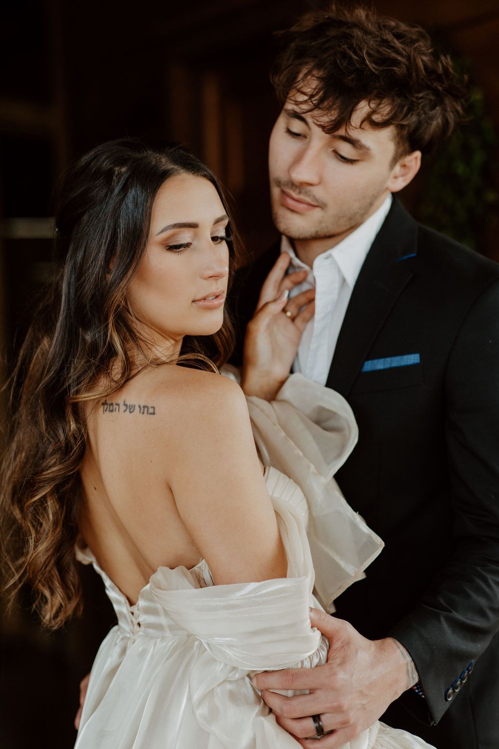 Intimate wedding portrait showcasing an off-shoulder dress and elegant styling.