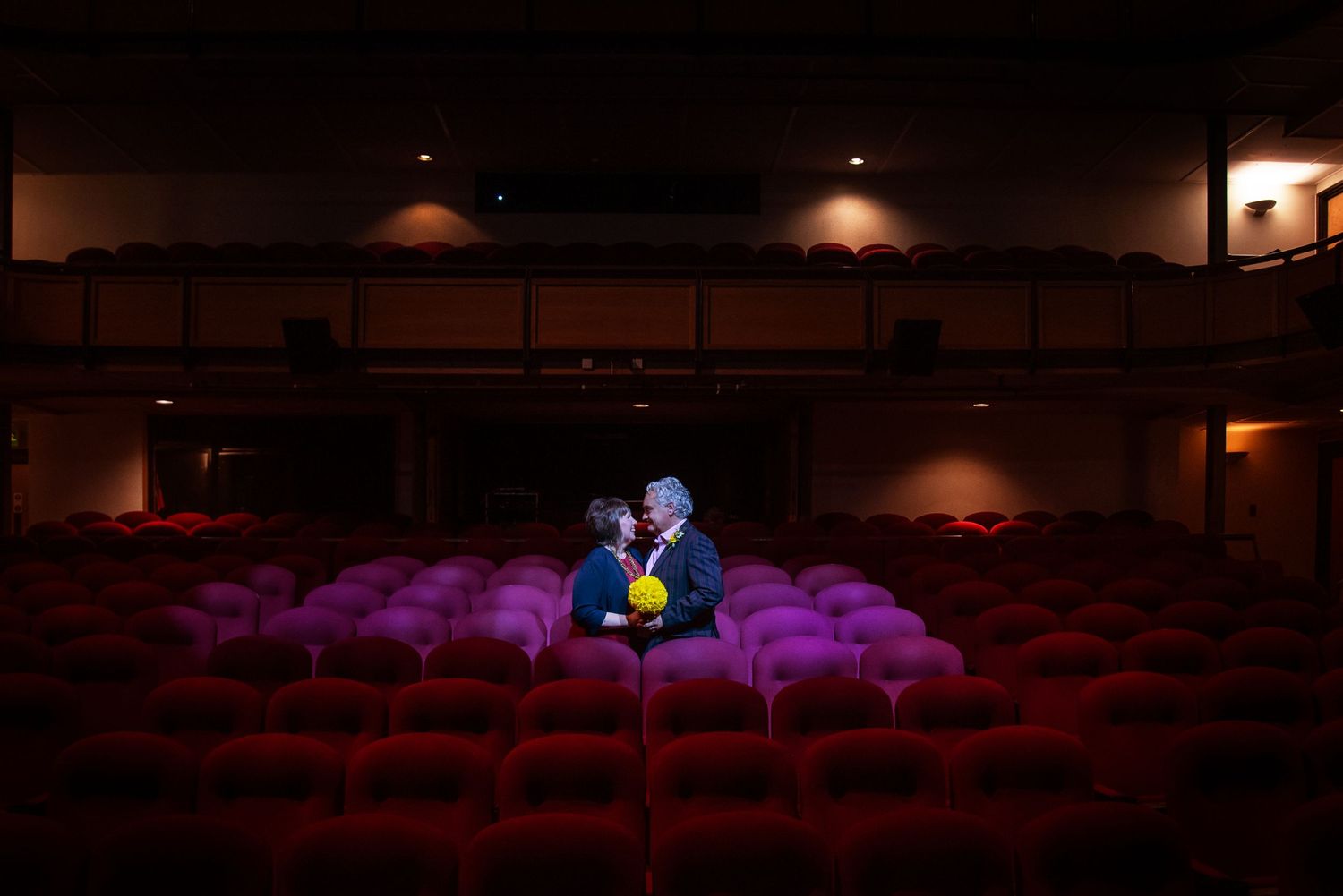 Dramatic theater seating with purple lighting creating an atmospheric ambiance.