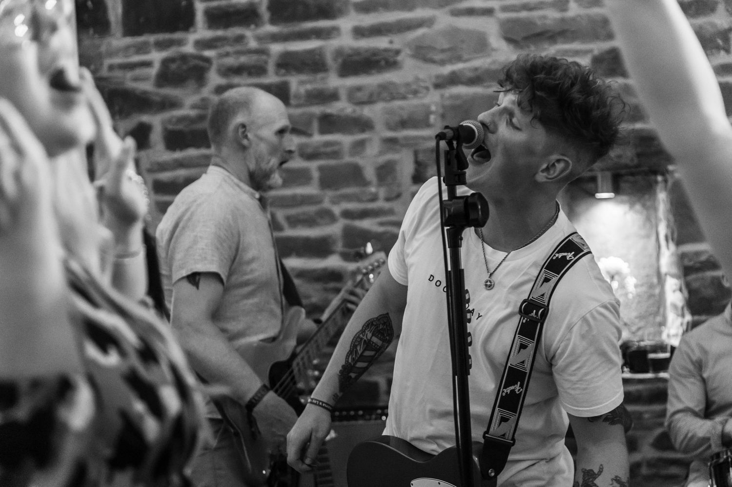 Black and white photograph of musicians performing on stage with instruments.