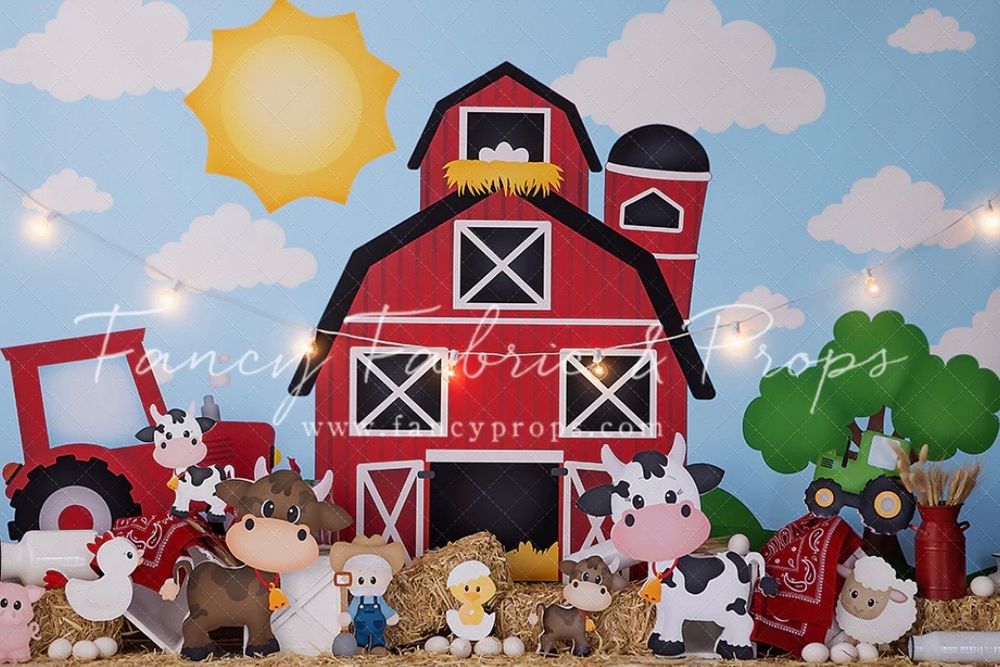 Cute barnyard themed photo backdrop with red barn, farm animals, and tractor against blue sky with bright sun.