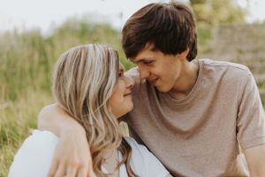 A sweet candid moment between a couple gazing at each other in a sunny outdoor setting.