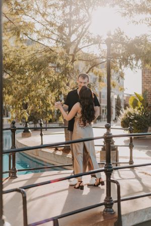 A couple dancing together on a paved walkway with trees in the background.