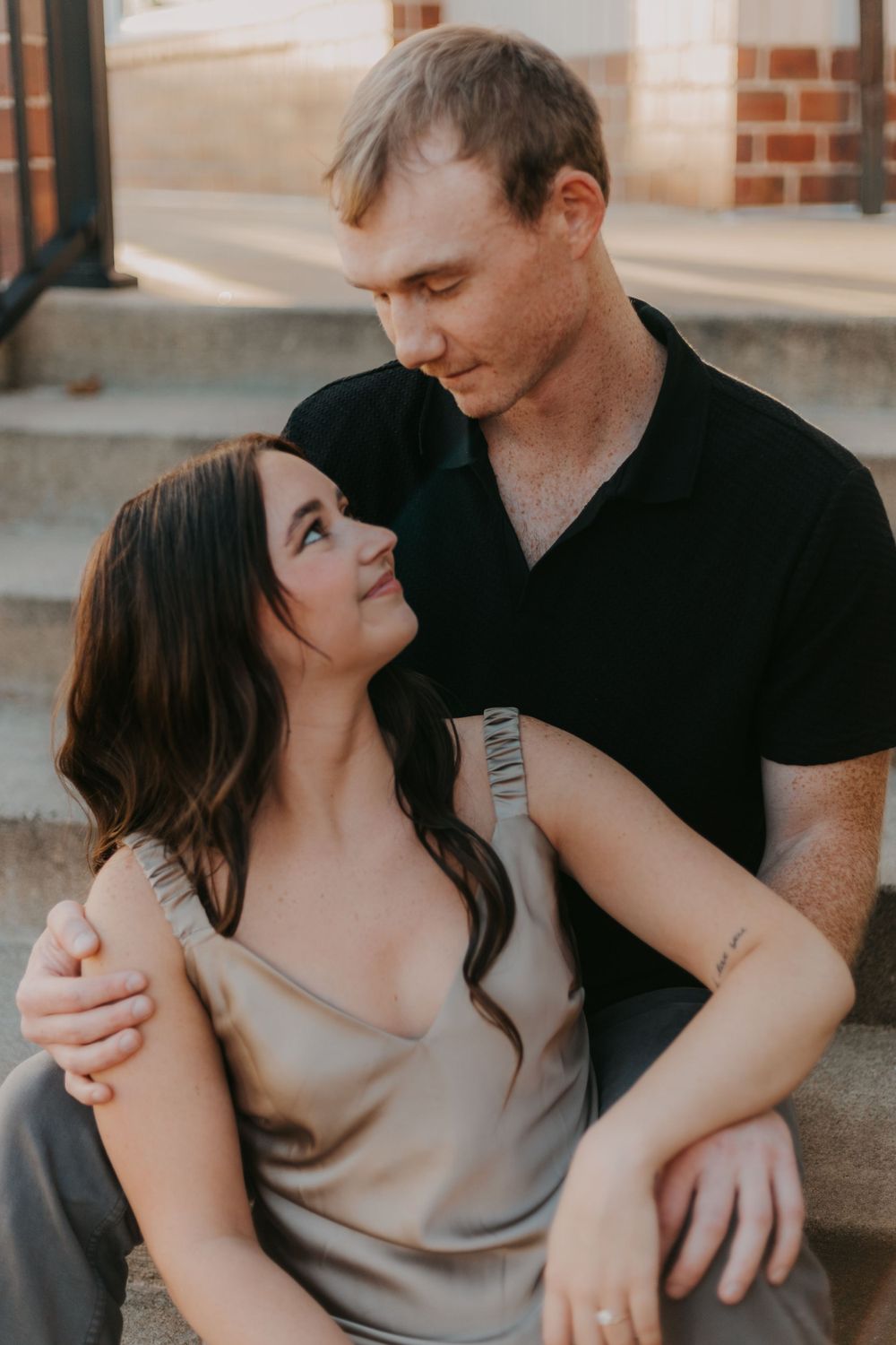 An intimate romantic moment captured on urban steps in warm golden light.
