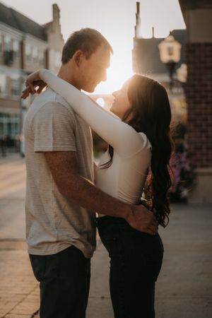 A loving embrace silhouetted against the golden sunset on a city street.