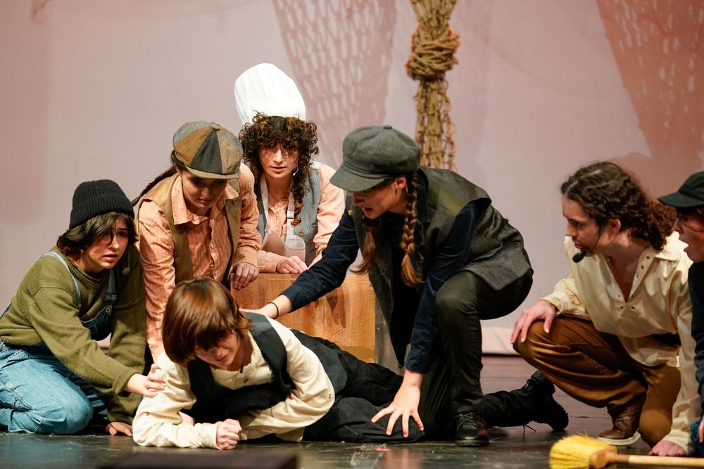 High school students performing on stage during a school play, colorful theater lights and expressions captured by SRX Media Group.