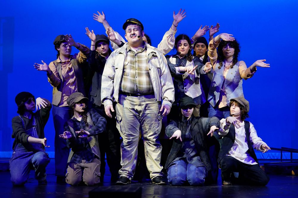 High school students performing on stage during a school play, colorful theater lights and expressions captured by SRX Media Group.